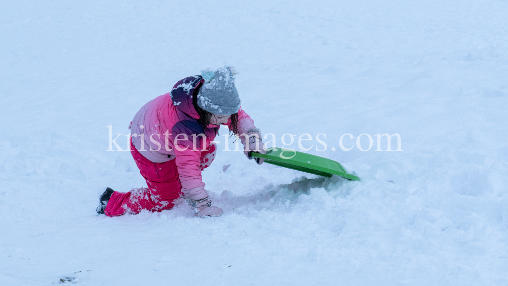 Kinder rodeln mit ihren Schneetellern by kristen-images.com