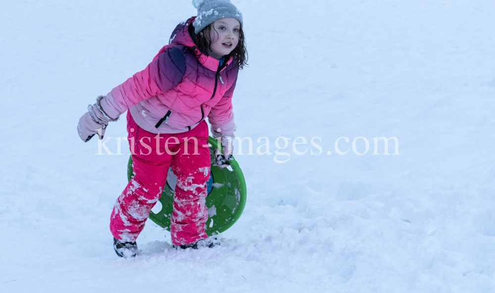 Kinder rodeln mit ihren Schneetellern by kristen-images.com