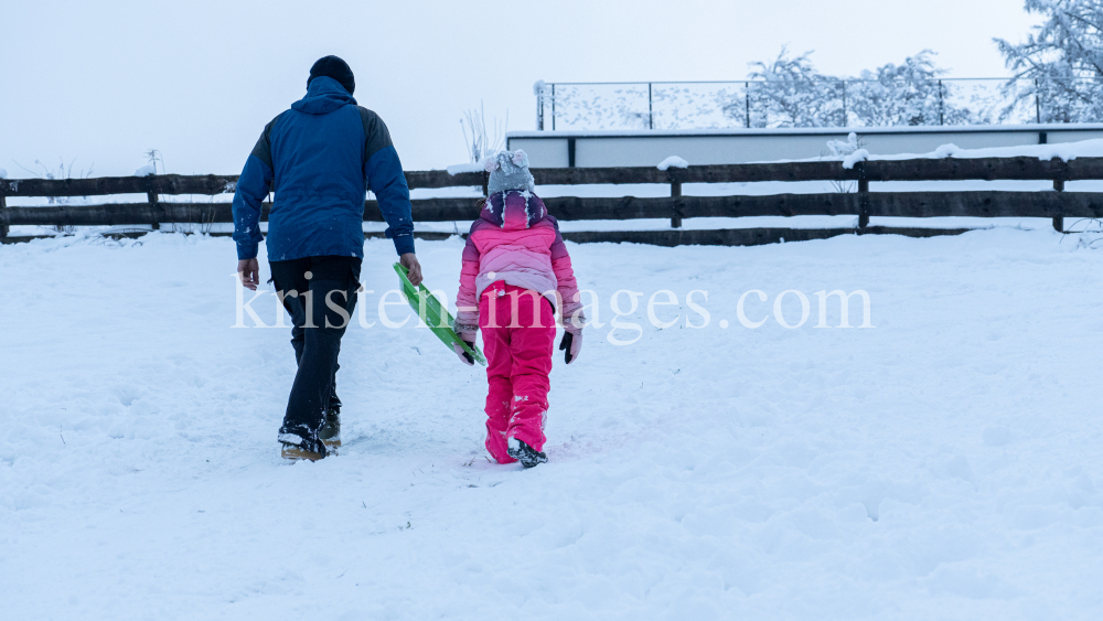 Kinder rodeln mit ihren Schneetellern by kristen-images.com