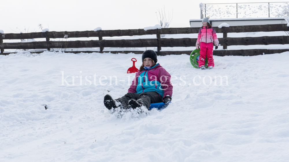 Kinder rodeln mit ihren Schneetellern by kristen-images.com