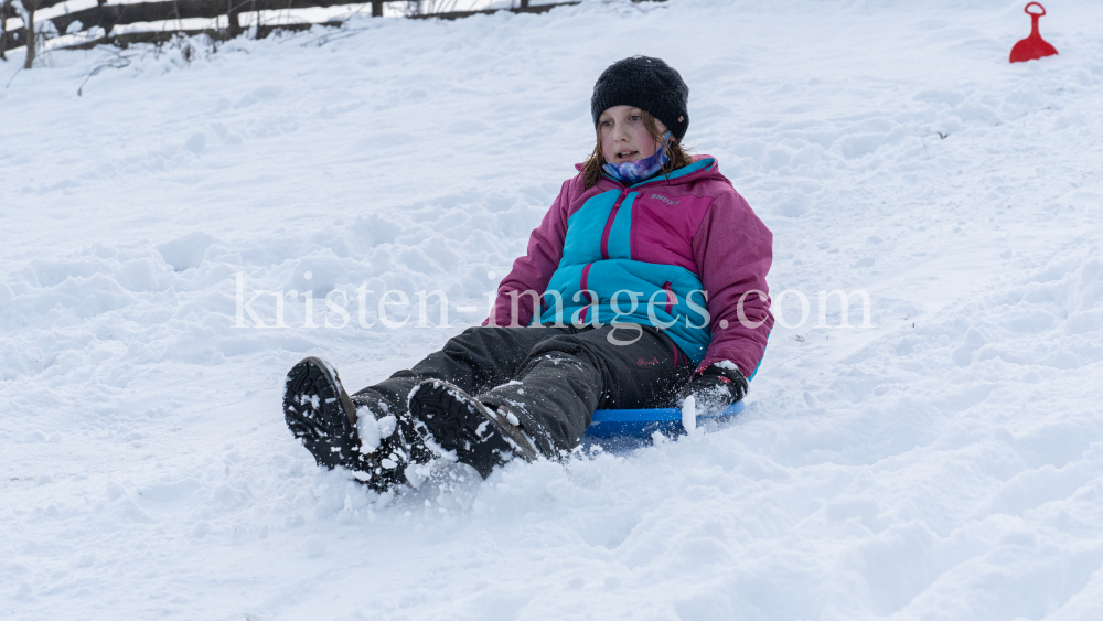 Kinder rodeln mit ihren Schneetellern by kristen-images.com