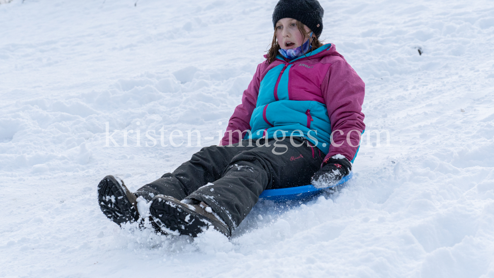 Kinder rodeln mit ihren Schneetellern by kristen-images.com