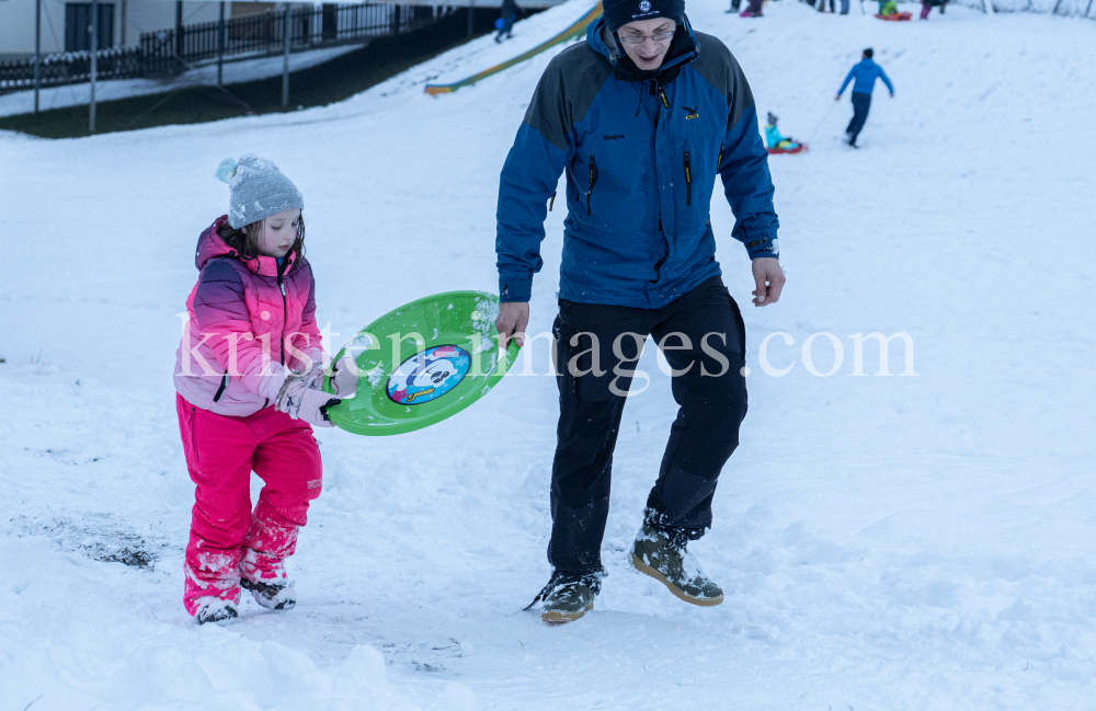 Kinder rodeln mit ihren Schneetellern by kristen-images.com