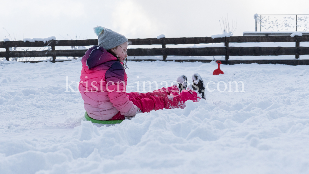 Kinder rodeln mit ihren Schneetellern by kristen-images.com