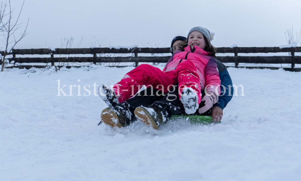 Kinder rodeln mit ihren Schneetellern by kristen-images.com