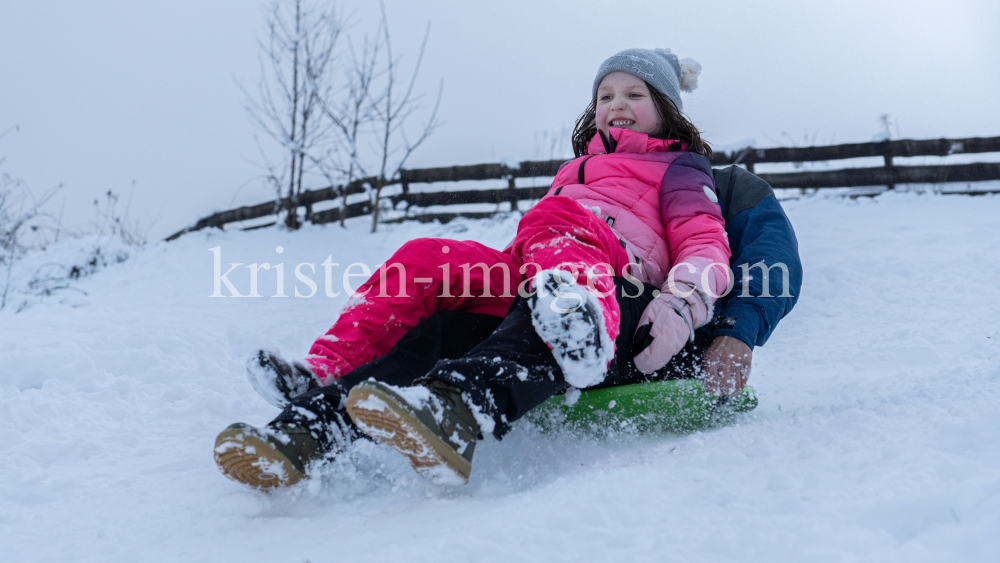 Kinder rodeln mit ihren Schneetellern by kristen-images.com