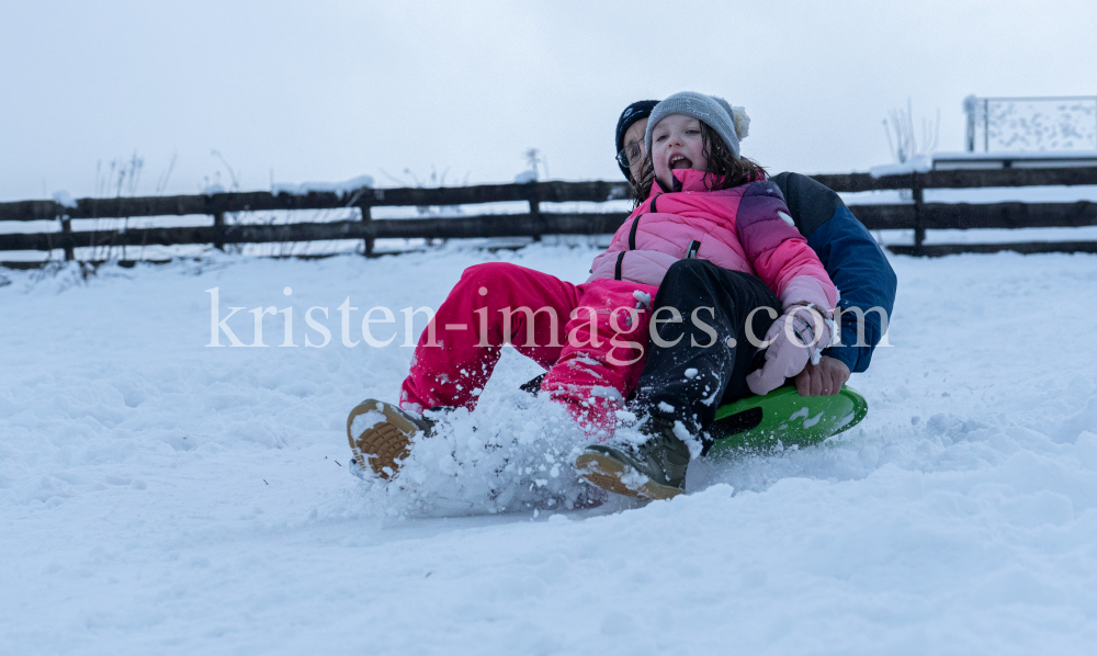 Kinder rodeln mit ihren Schneetellern by kristen-images.com