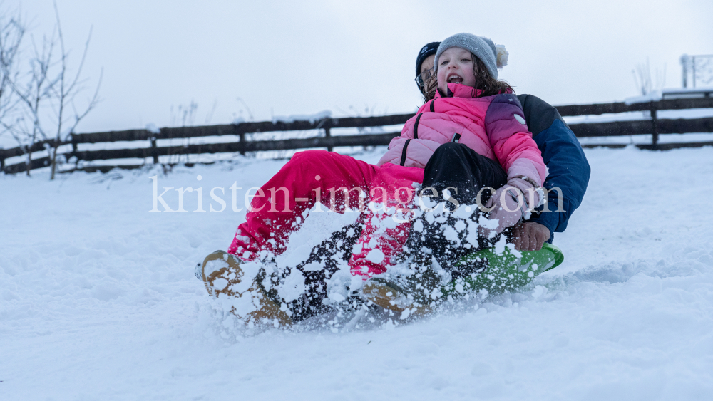 Kinder rodeln mit ihren Schneetellern by kristen-images.com