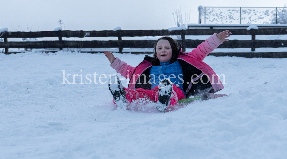 Kinder rodeln mit ihren Schneetellern by kristen-images.com