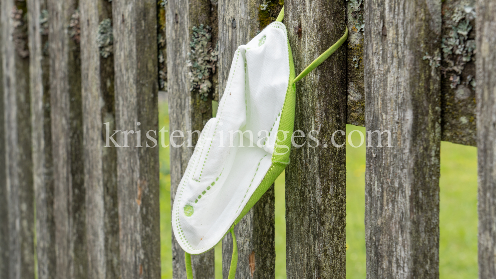 FFP2-Maske hängt am Gartenzaun by kristen-images.com