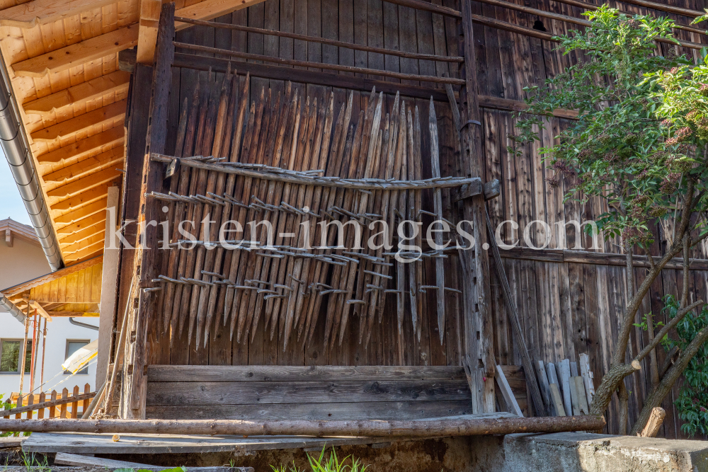 Stangger zum Heutrocknen an einer Scheune / Aldrans, Tirol, Österreich by kristen-images.com