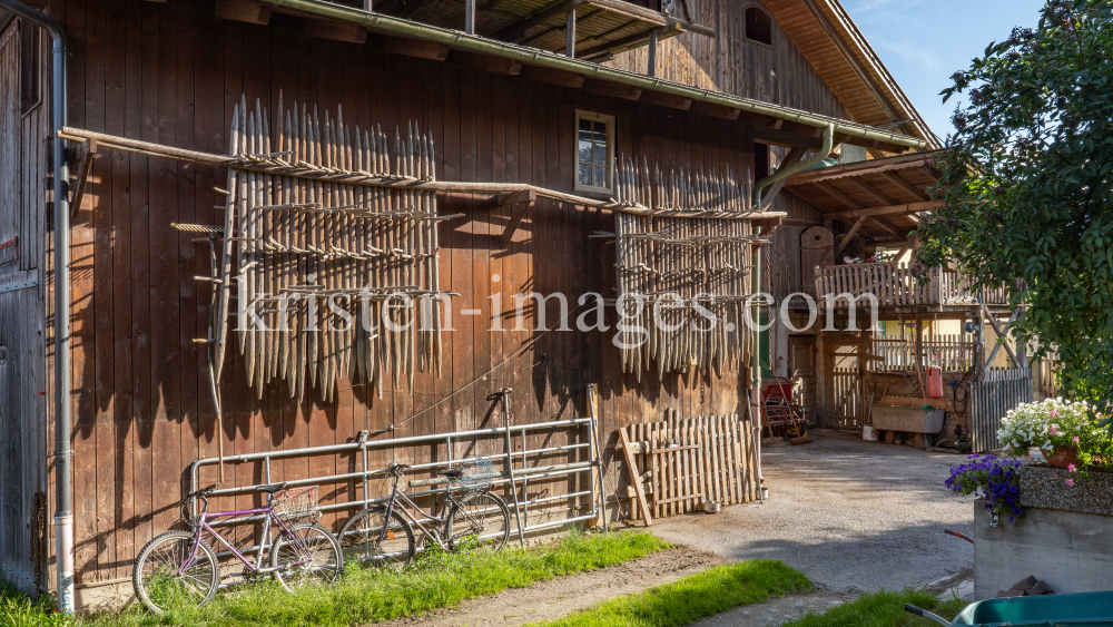 Stangger zum Heutrocknen an einer Scheune / Aldrans, Tirol, Österreich by kristen-images.com