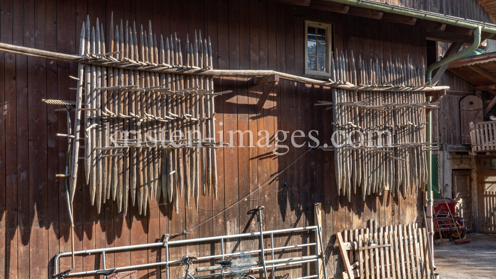 Stangger zum Heutrocknen an einer Scheune / Aldrans, Tirol, Österreich by kristen-images.com