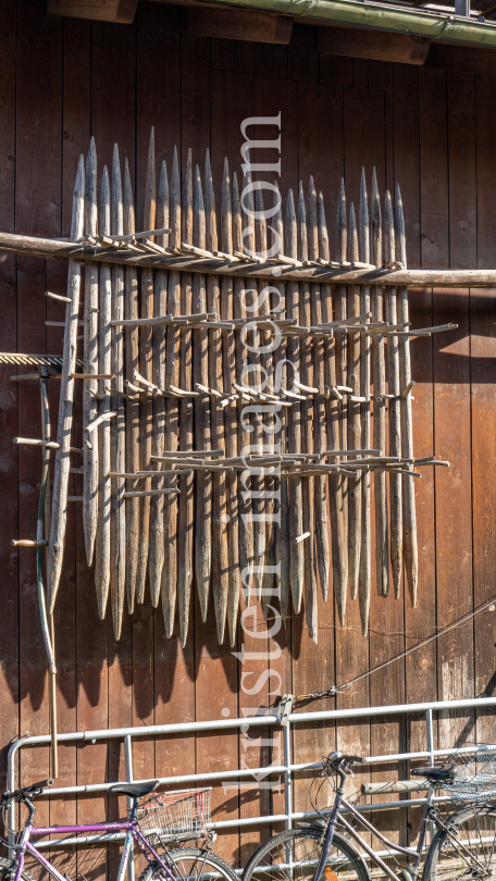 Stangger zum Heutrocknen an einer Scheune / Aldrans, Tirol, Österreich by kristen-images.com