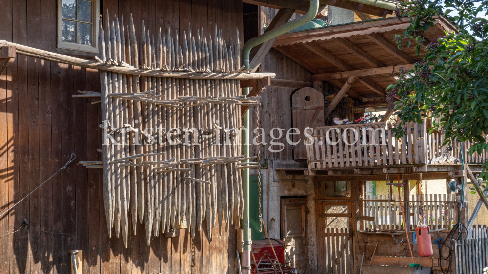 Stangger zum Heutrocknen an einer Scheune / Aldrans, Tirol, Österreich by kristen-images.com