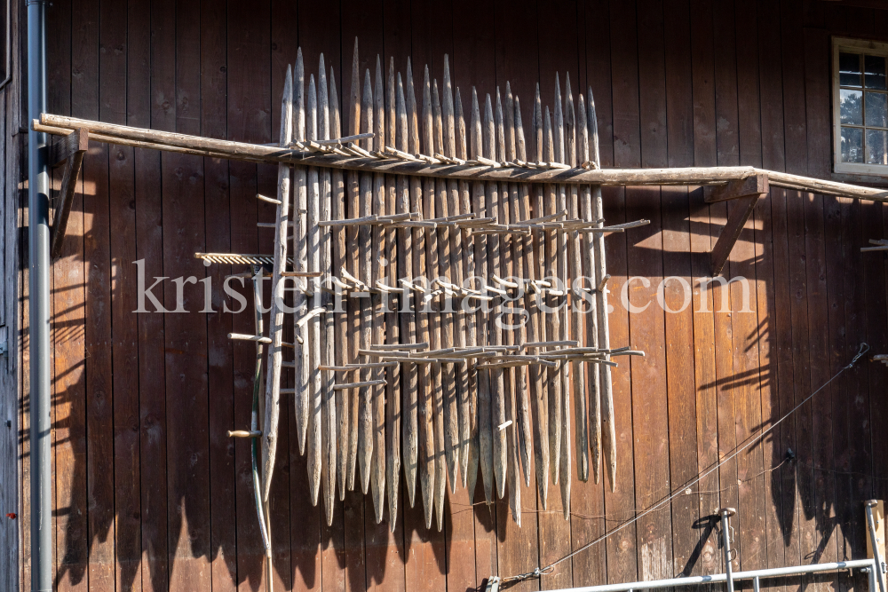 Stangger zum Heutrocknen an einer Scheune / Aldrans, Tirol, Österreich by kristen-images.com