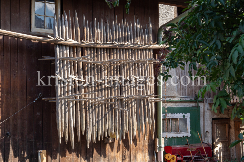 Stangger zum Heutrocknen an einer Scheune / Aldrans, Tirol, Österreich by kristen-images.com