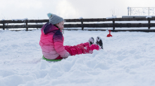 Kinder rodeln mit ihren Schneetellern