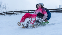 Kinder rodeln mit ihren Schneetellern