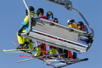 Skifahrer mit Maske am Sessellift