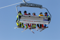 Skifahrer mit Maske am Sessellift