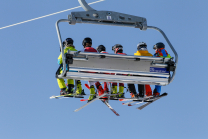 Skifahrer mit Maske am Sessellift