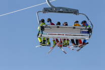 Skifahrer mit Maske am Sessellift