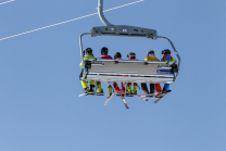 Skifahrer mit Maske am Sessellift