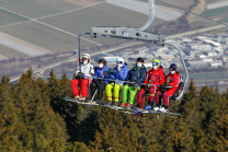 Skifahrer mit Maske am Sessellift