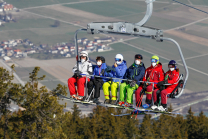 Skifahrer mit Maske am Sessellift