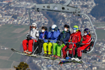 Skifahrer mit Maske am Sessellift