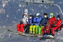 Skifahrer mit Maske am Sessellift