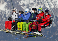 Skifahrer mit Maske am Sessellift