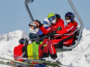 Skifahrer mit Maske am Sessellift