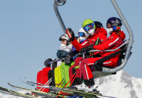 Skifahrer mit Maske am Sessellift