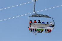 Skifahrer mit Maske am Sessellift